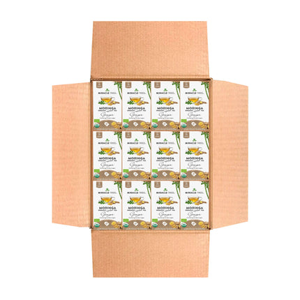 An open cardboard box displays packets of Miracle Trees Organic Moringa Tea, Ginger. The green and white packaging features leaf graphics and emphasizes superfood benefits. The box flaps are open, revealing neatly arranged caffeine-free herbal tea packets inside.