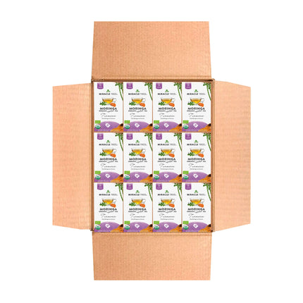 An open cardboard box reveals stacked packets of Miracle Tree Organic Moringa Tea, Turmeric. Each packet features vibrant green and purple designs, highlighting its organic status and showcasing nutritional icons celebrating its superfood qualities.
