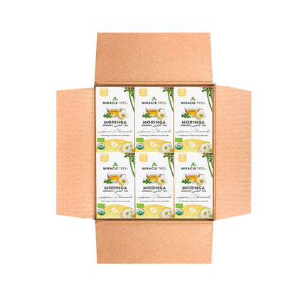 Open cardboard box displaying eight Miracle Tree Organic Moringa Tea, Lemon & Chamomile boxes, a caffeine-free superfood in green and white packaging featuring moringa leaves and flowers.