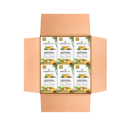 Open cardboard box with six packets of Miracle Trees caffeine-free Organic Moringa Tea, Honey & Vanilla. The superfood packaging displays a leaf design and branding details.