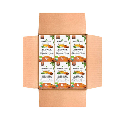 Open a cardboard box to find packages of Miracle Trees Organic Moringa Tea in Pumpkin Spice flavor. These caffeine-free packages beautifully feature images of pumpkins and moringa leaves, capturing the essence of this refreshing blend.