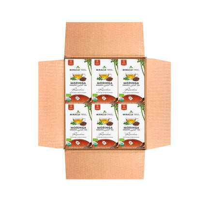 Open cardboard box with six Miracle Tree Organic Moringa Tea, Rooibos boxes. Neatly arranged, the packaging displays a green and white design featuring moringa leaves.