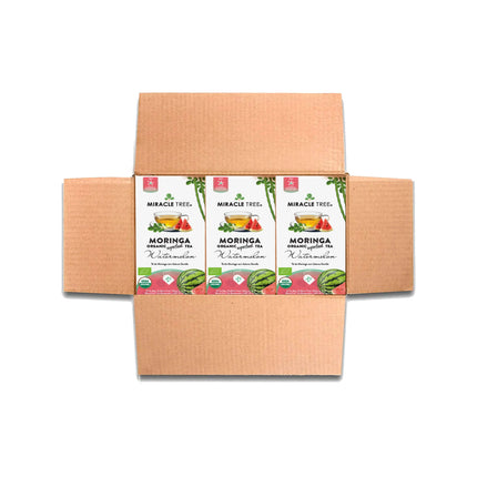 A cardboard box displays three Miracle Tree Organic Moringa Tea packets in Watermelon flavor. The packaging shows colorful tea leaves and watermelon images, text, and organic certification logos on a white background. Savor the pure essence of this caffeine-free beverage.