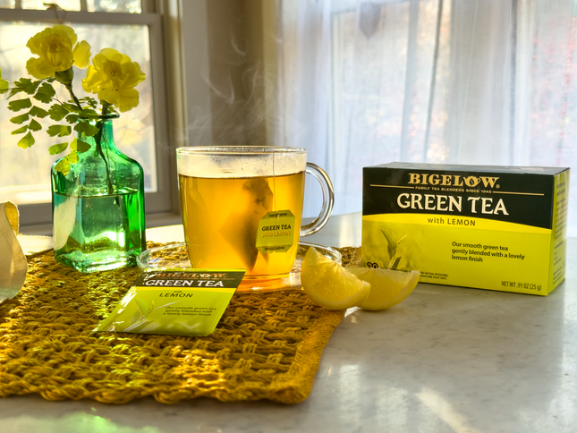 Cup of Green Tea with Lemon with vase of flowers